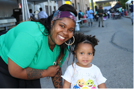 2023 OIC Philadelphia Block Party - staff with child smiling